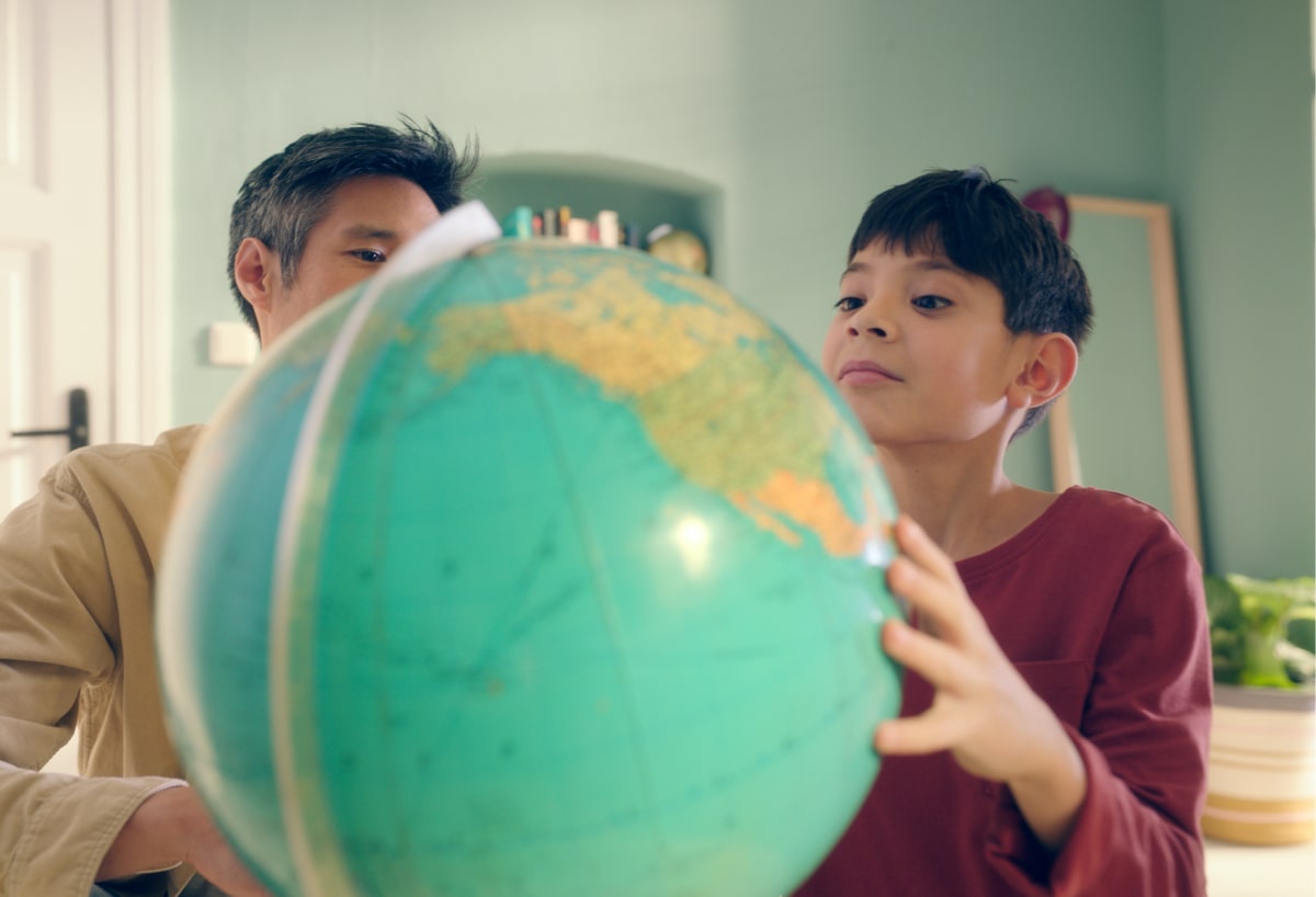Young boy looking at a globe