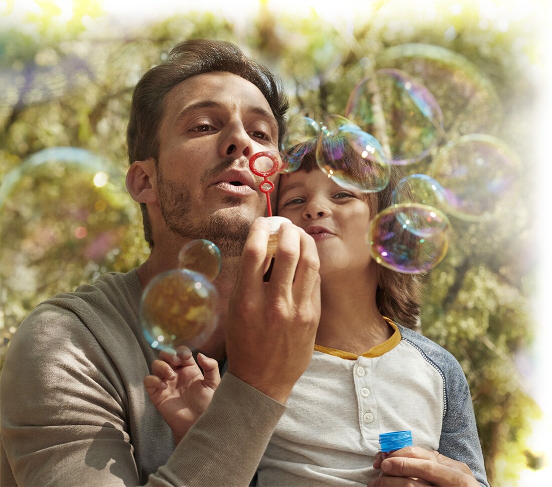 Father blows bubbles with Son