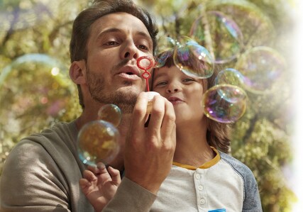 Father blows bubbles with Son