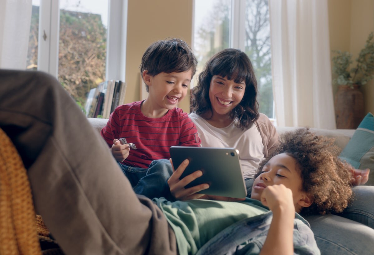 Woman with two young boys playing with an iPad