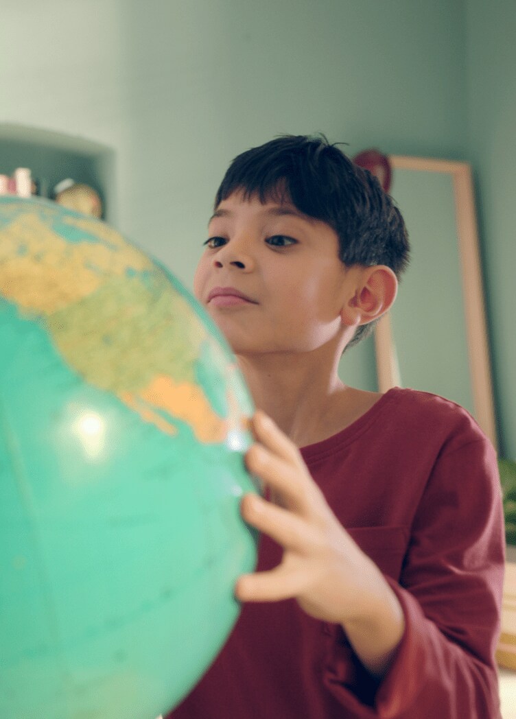 Young boy looks at globe