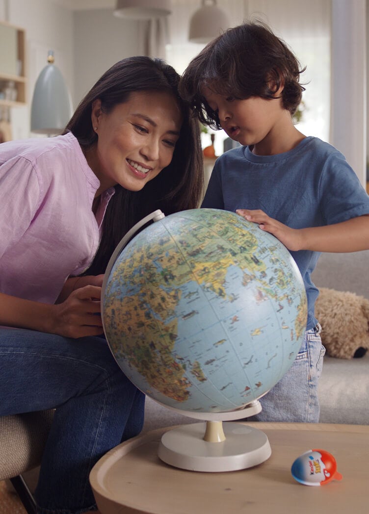 Young boy looks at globe