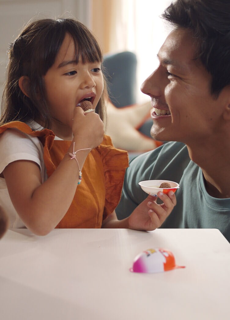 Father and daughter eat Kinder together