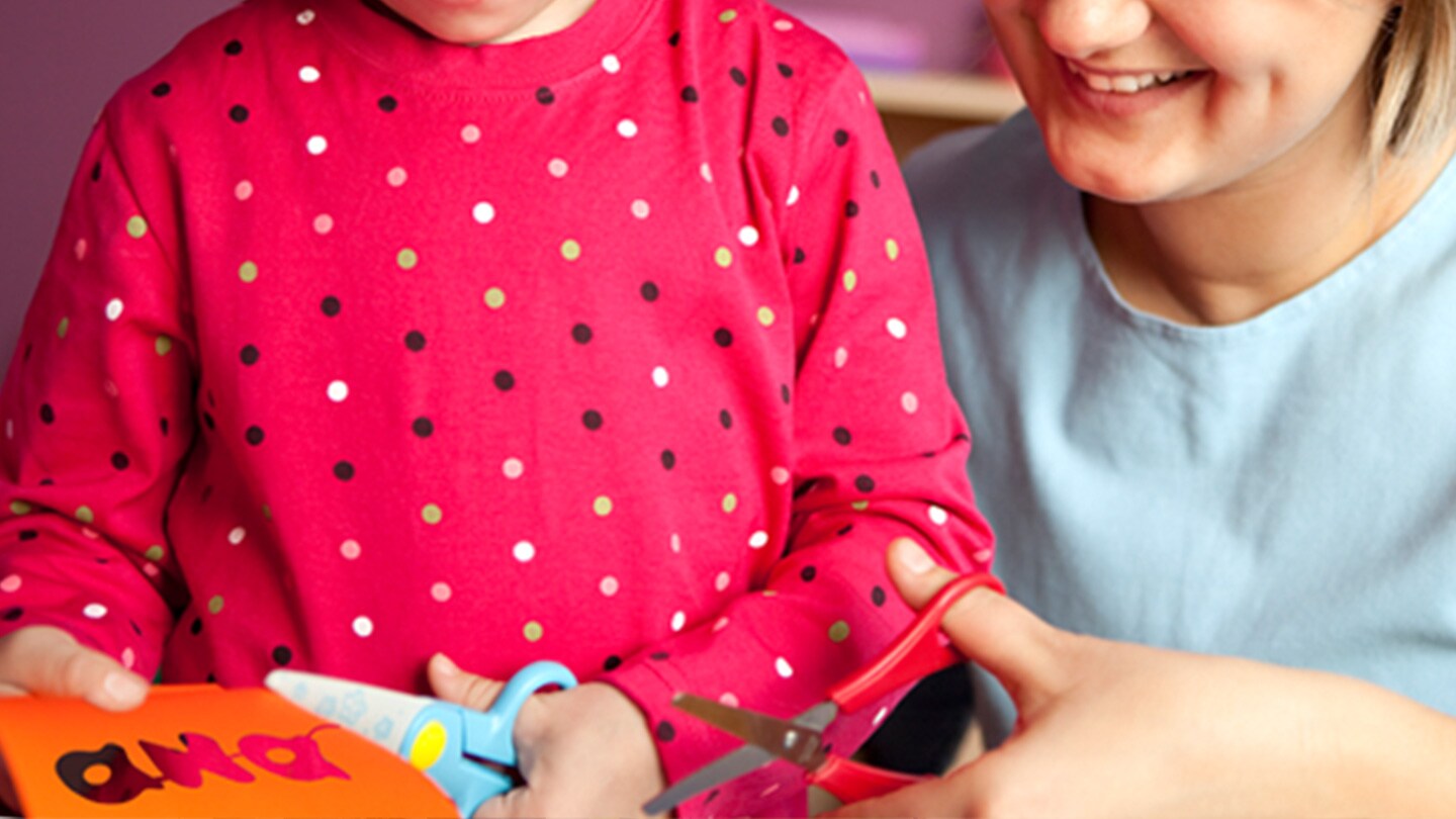 Mamá e hija haciendo manualidades recortando papel.