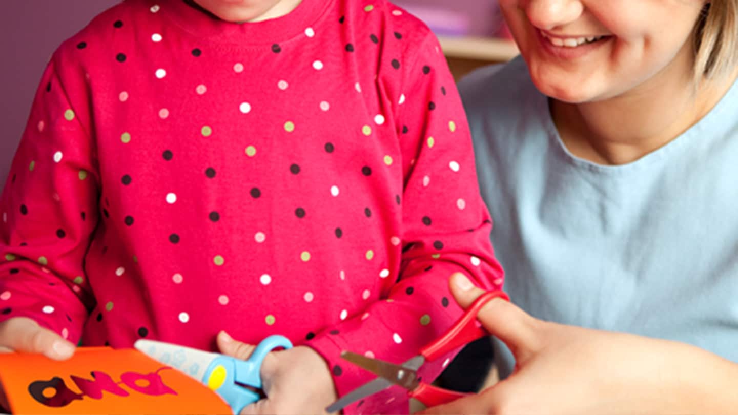 Mamá e hija haciendo manualidades recortando papel.
