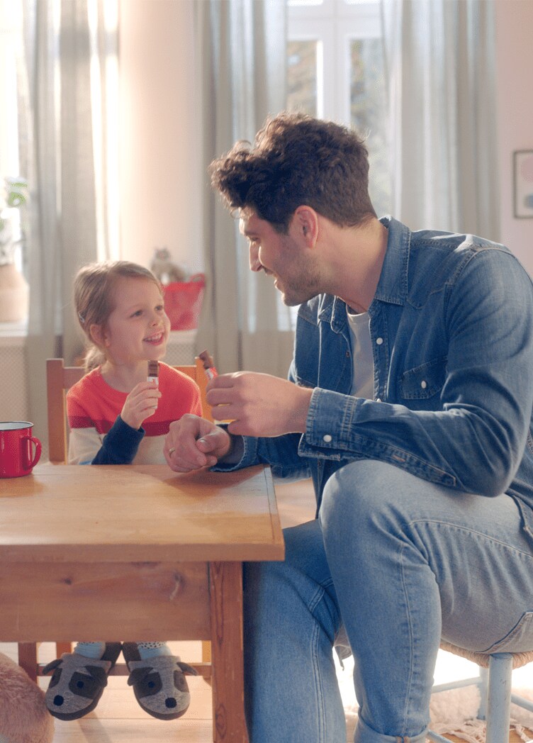 Father and daughter eat Kinder together