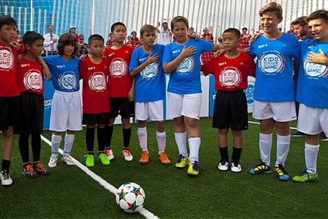 Activities around the world Barn från olika länder som väntar på att börja spela en fotbollsmatch vid ett Kinder+ Sport-evenemang